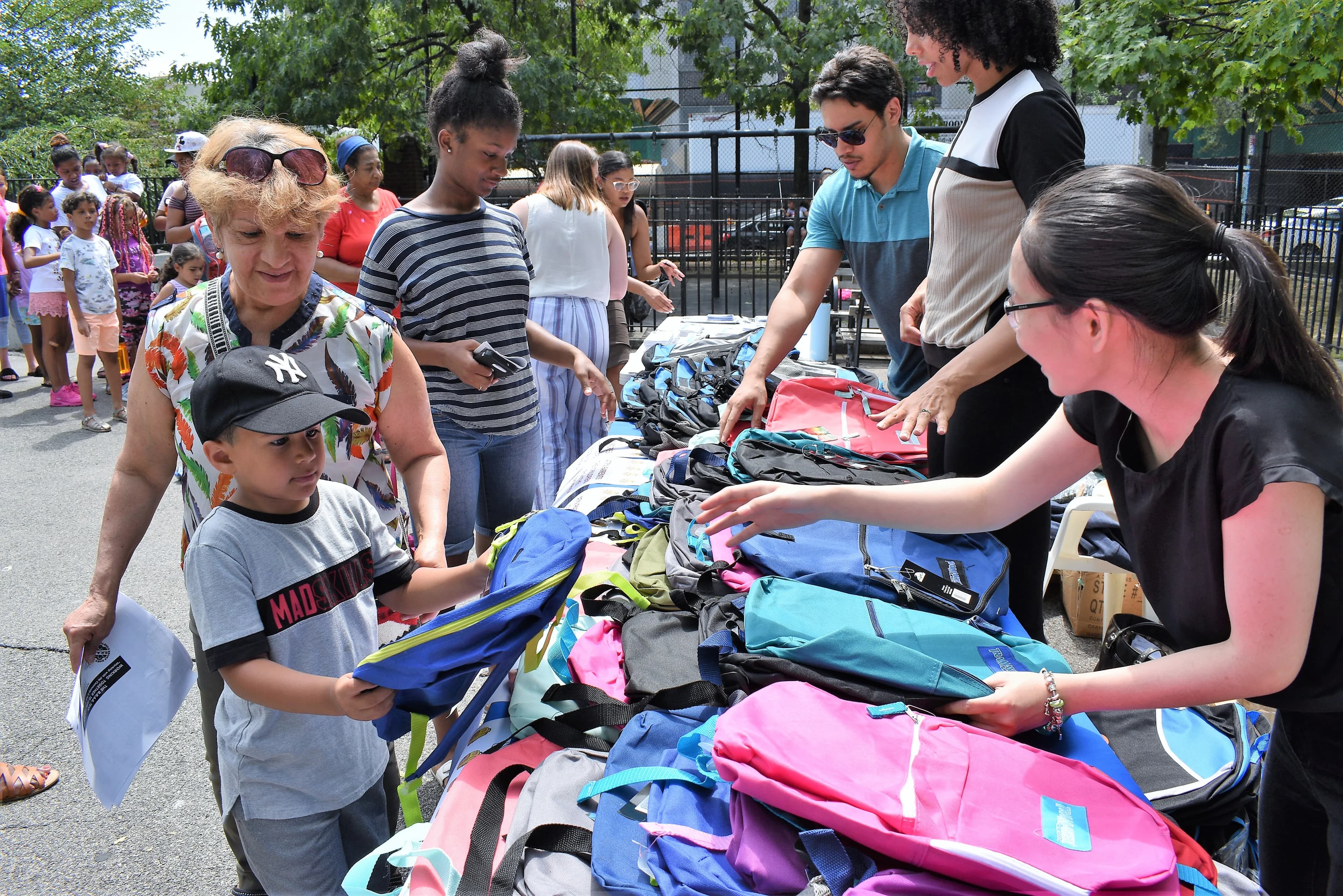 Community members receiving backpacks and supplies at a Queens Community Closet event